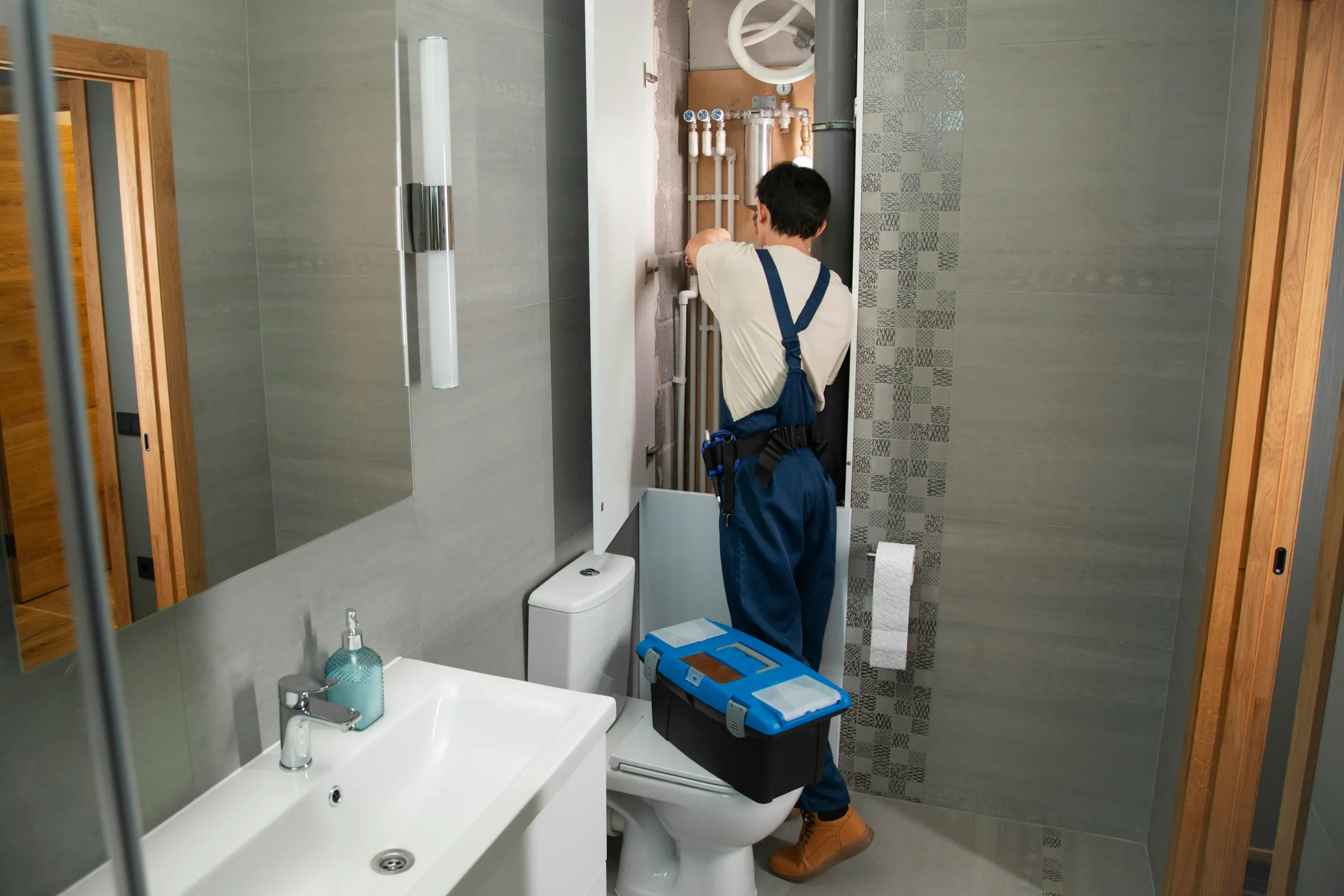 Plombier en intervention sur une fuite d'eau dans une salle de bain